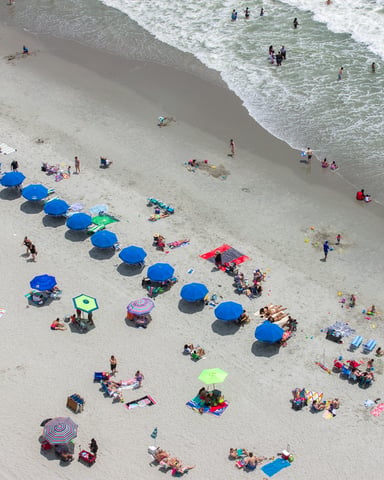 Aerial view of Myrtle Beach with colorful beach umbrellas and swimmers along the shoreline
